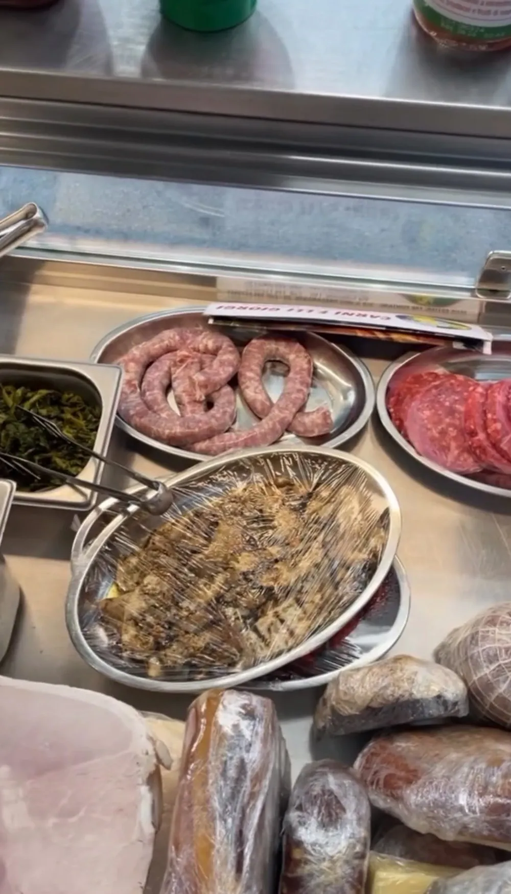 Il banco del truck con salsiccia, hamburger, verdure e ingredienti per i panini
